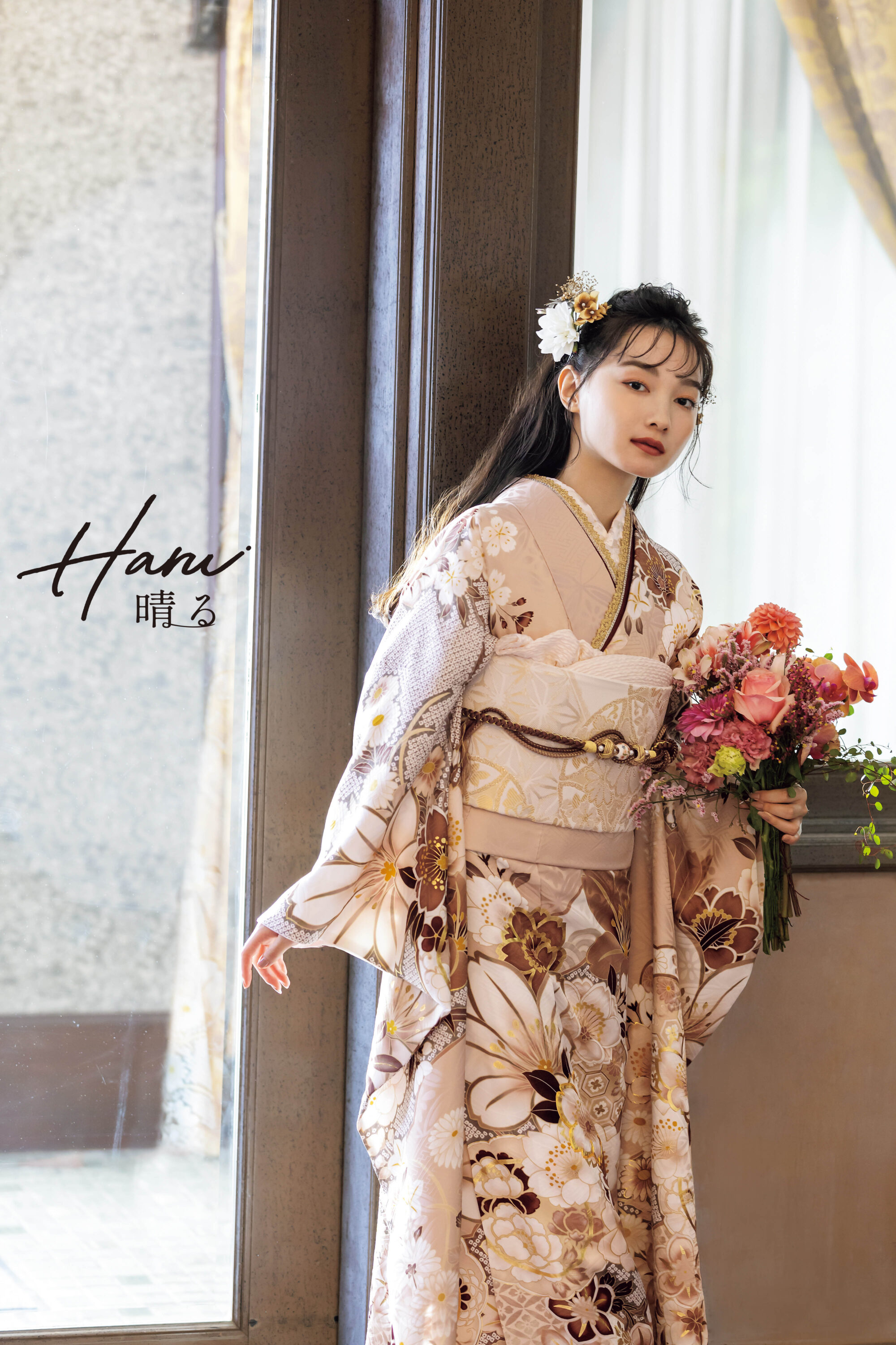 花柄の着物を着た女性が、大きな窓の近くの屋内に立っています。彼女は鮮やかなピンクとオレンジの花束を持っています。彼女の髪は白い花で飾られており、少し横を向いています。画像には「波見晴る」という文字があります。